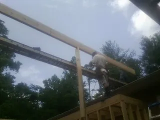 Carpenter setting a ridge beam over a new addition frame — Ice Dam Removal by Roofing Brothers in Union Springs