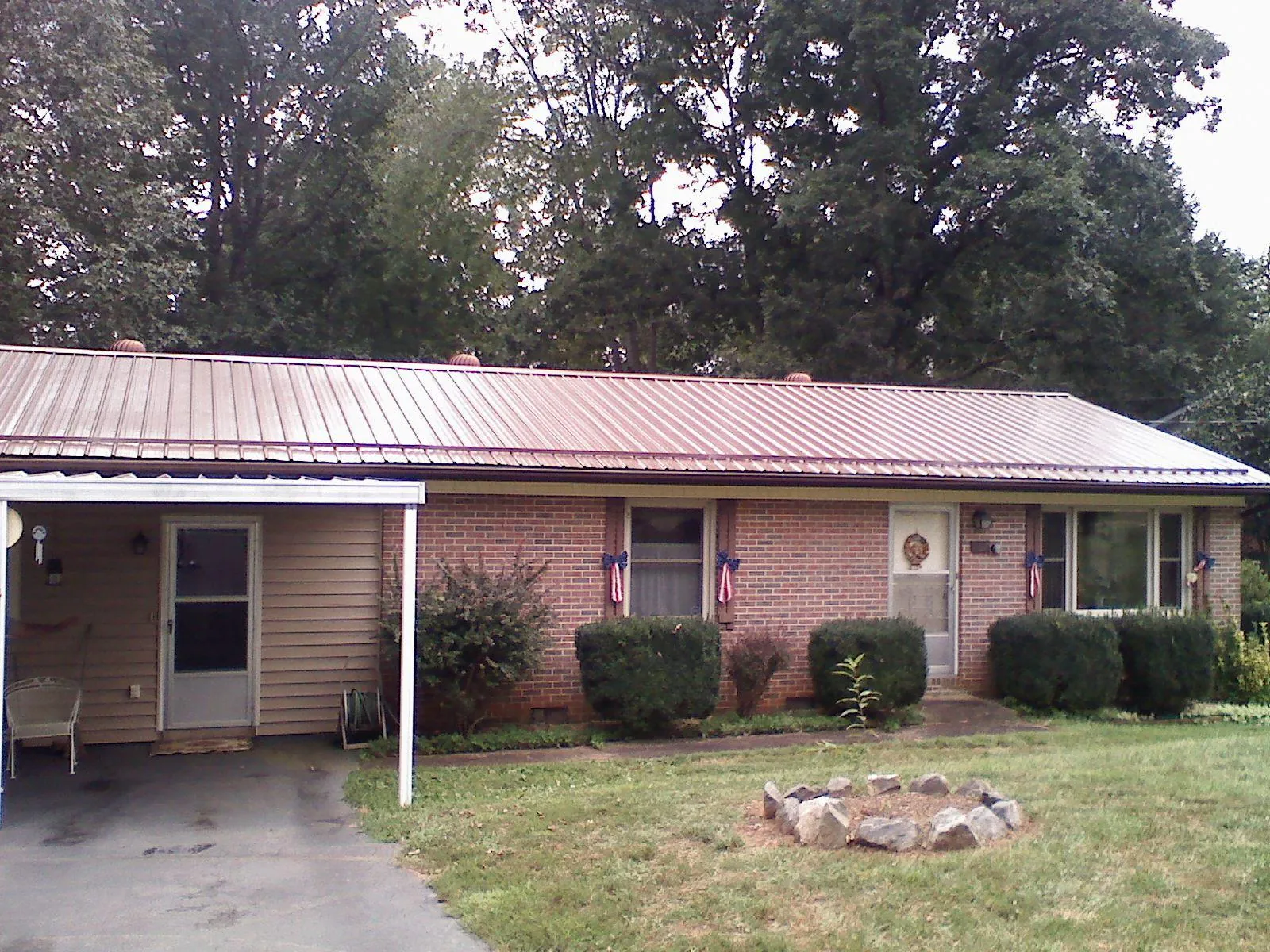 Bronze metal roof and carport on a brick ranch home — Roof Repair work by our crew in Union Springs